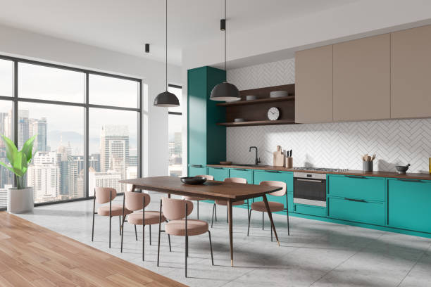 istock Modern kitchen interior with teal cabinets and wooden table, light-filled space with large windows overlooking a cityscape. Concept of contemporary home design. 3D Rendering. 2162868611