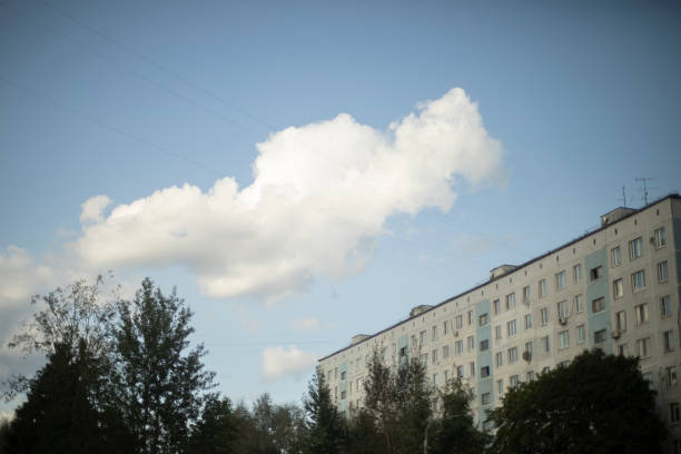 Cloud over the house. The urban landscape. A white cloud in a blue sky. Summer day in the city.