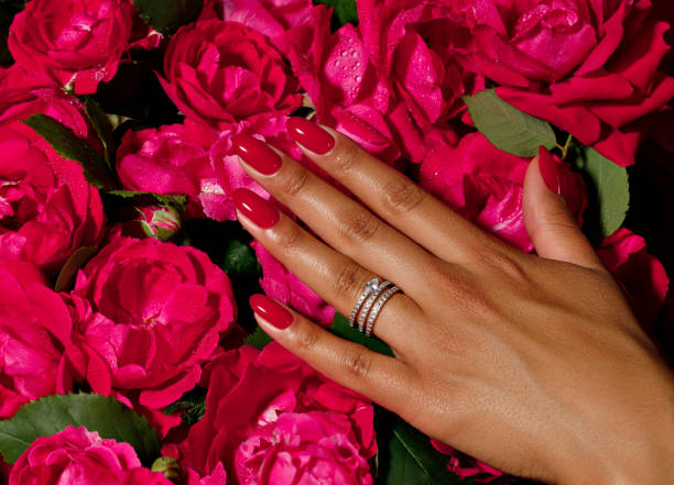istock hands with red rose petals, hands with red manicure 2162872648