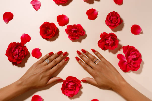 istock hands with red rose petals, hands with red manicure 2162872678
