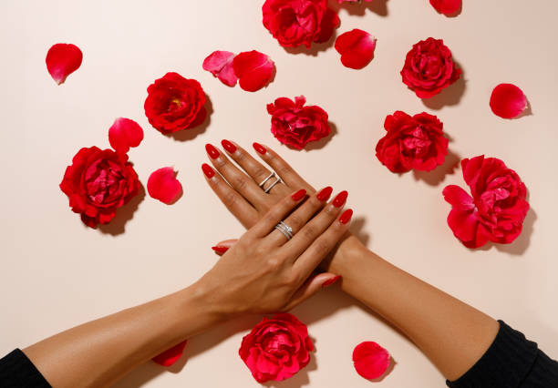 hands with red rose petals, hands with red manicure