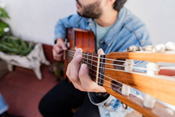 Close-up of a man playing guitar in the backyard