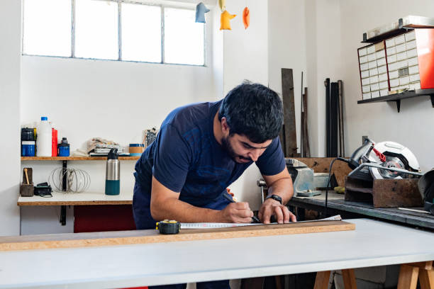 istock Mid adult carpenter using tape measure in a carpentry 2162874984