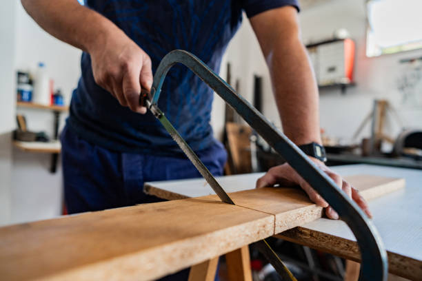 Close-up of a carpenter using hand saw in a carpentry