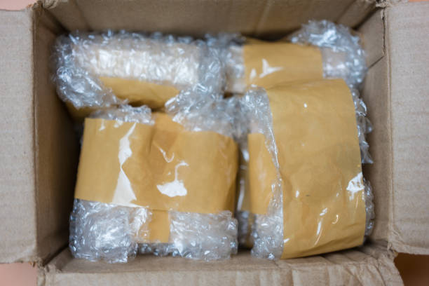 istock Packing fragile items with plastic air bubble wrapped and adhesive tape in box. 2162875053