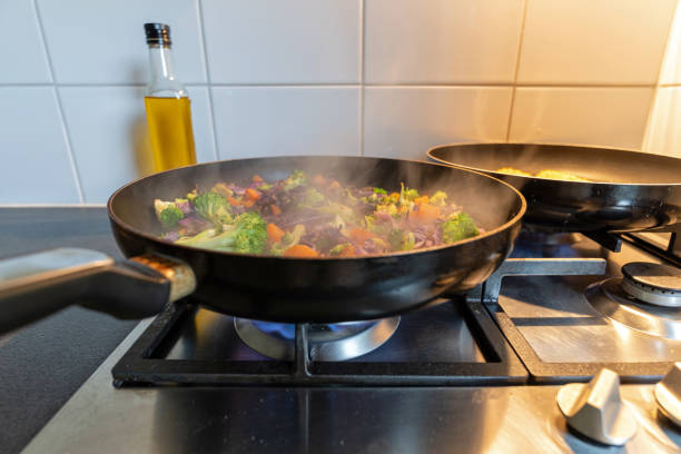 cooking vegetables in a coated pan on a gas stove