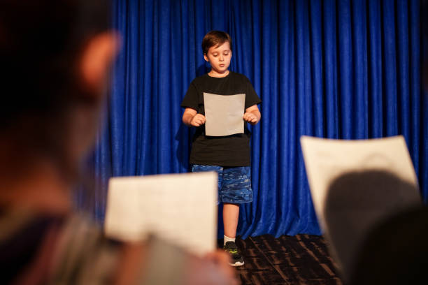 istock Kid is performing on stage with text sheet, acting class rehearsals. 2162876931