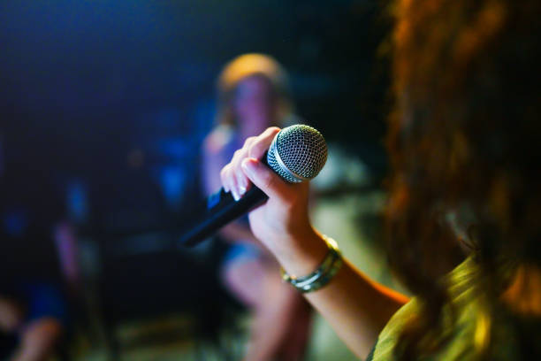 istock Close up to a microphone in hand at the stage. 2162879001
