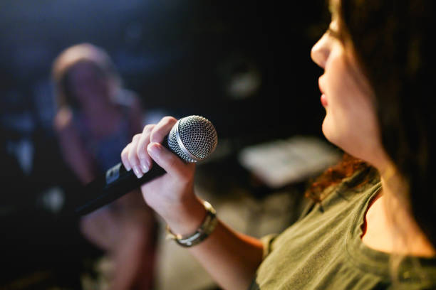 istock Close up to a microphone in hand at the stage. 2162879052