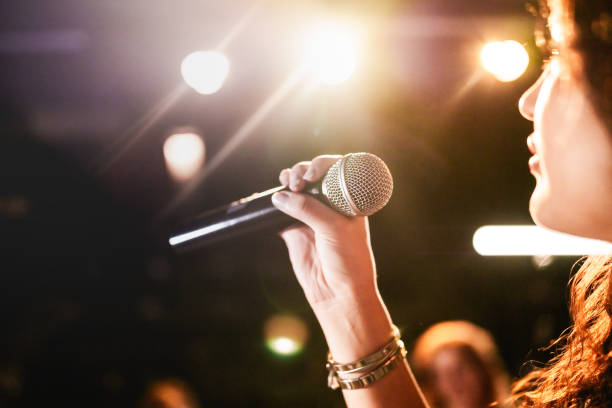 istock Close up to a microphone in hand at the stage. 2162879115