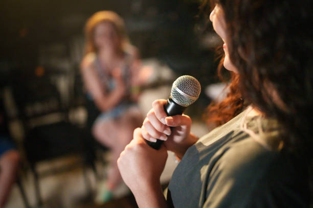 istock Close up to a microphone in hand at the stage. 2162879118