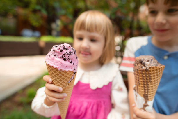 istock Cute children enjoying ice-cream in summer park 2162880751