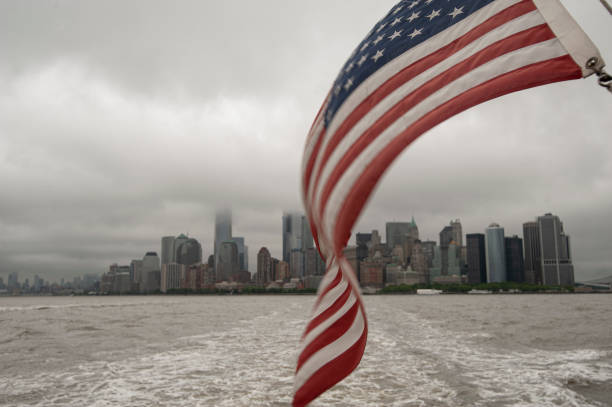 American flag, Ellis island boat, May 30, 2017,American flag waving at the back of the boat going to Ellis Island while the Manhattan skyline is visible at the back.