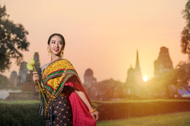 Women in Thai traditional dress in temple on big Budda background at Ayutthaya Thailand.