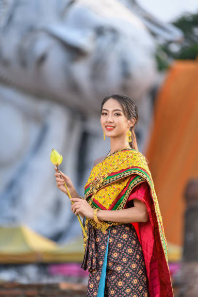 Women in Thai traditional dress in temple on big Budda background at Ayutthaya Thailand.