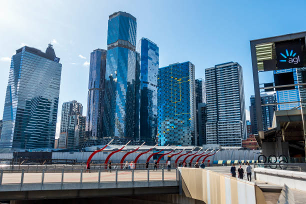 Melbourne, Australia - Sep 2, 2022: View of the AGL Building and other modern high-rise office architectures. Street level view. At the Southern Cross Bridge, Docklands. People walking around.