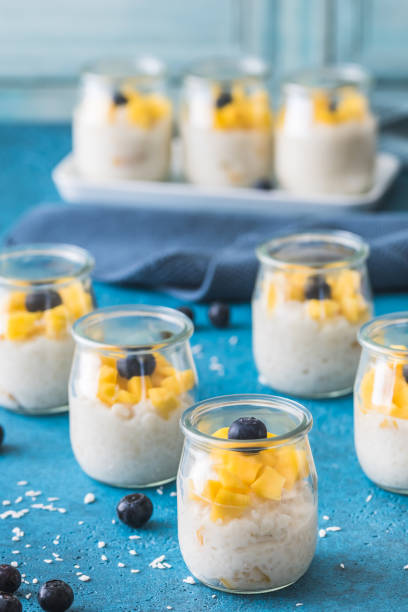 istock Rice pudding with mango in dessert glasses on blue background 2162893223