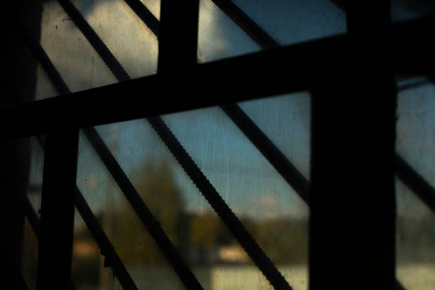 Grille on window. Steel bars across window. Interior details. Gloomy picture.
