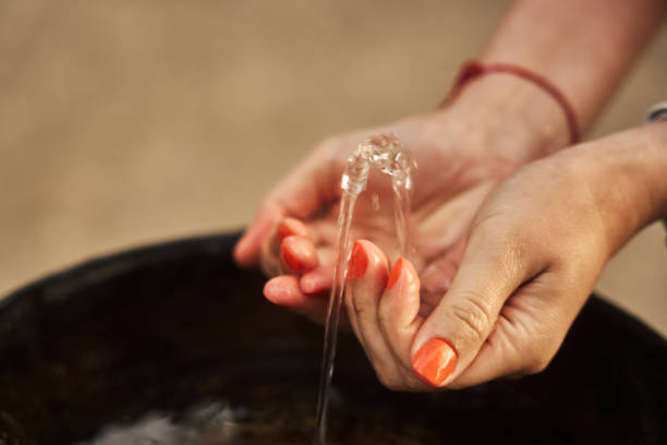 istock woman drinks water from her hand 2162898108