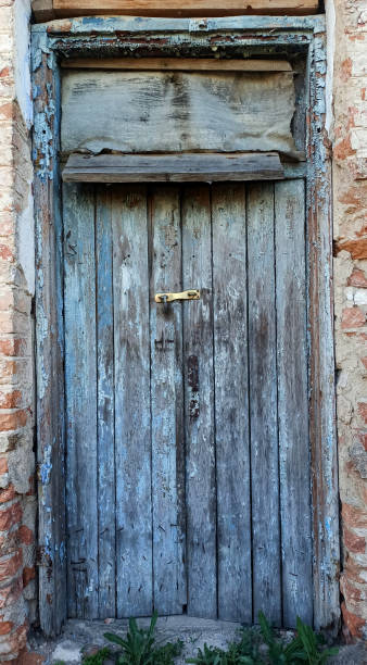 istock Old wooden door with a peeling paint with a lock 2162898596
