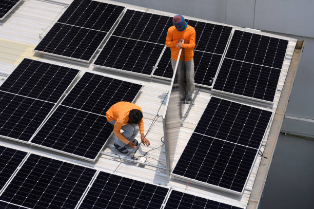 istock Worker installs solar panels. Worker installs solar panels at a solar farm field. 2162899489