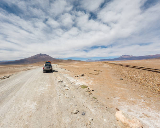 istock Desert road through sandy landscape under clear blue sky. 2162900173