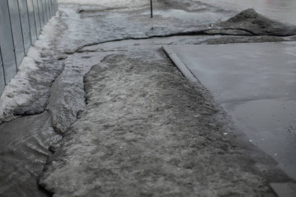 istock Dirty water flows on asphalt. Flow of water along road. Cloudy liquid. 2162901164