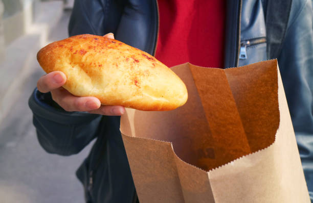 istock Hand picking out a soft baguette bread from paper bag, concept of save the earth with using non-plastic bags 2162902354