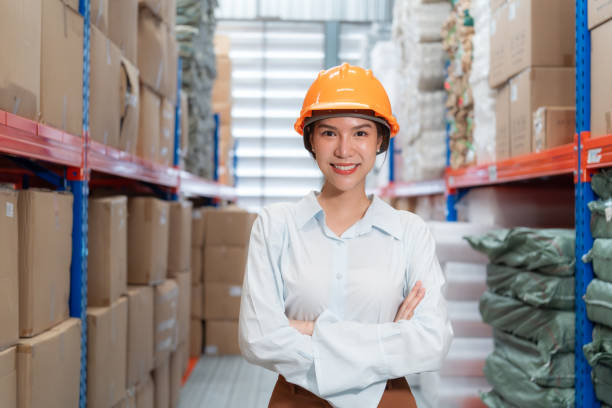 istock Smiling female warehouse worker in hard hat. 2162902431