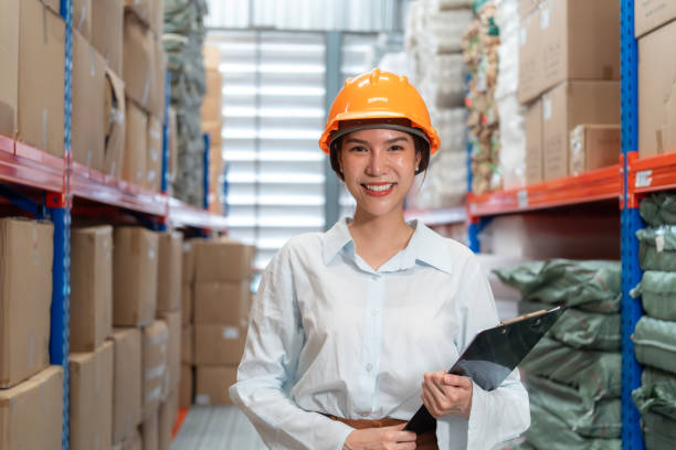 istock Smiling female warehouse worker in hard hat. 2162902440