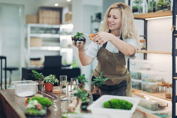 istock Young florist making an arrangement in a glass container 2162903520