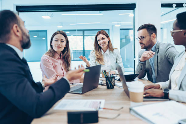 istock Business people sitting around a conference table and talking 2162903521