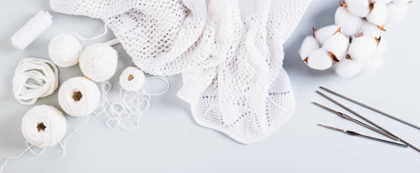 istock Knitting concept, balls, threads, hooks and knitting needles on a blue top view web banner 2162907857
