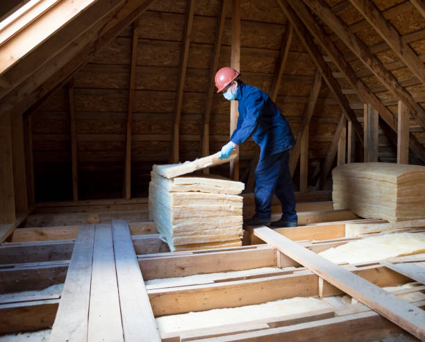 istock Roof insulation. A worker puts glass wool insulation in the attic. 2162908522