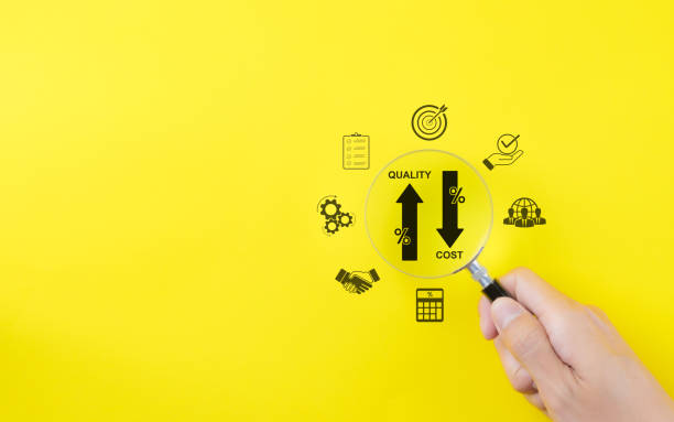 istock Effective business concept. Quality increase and cost reduction. Hand holds a magnifying glass over icons representing quality control increase, cost reduction, business efficiency, and optimization. 2162910878