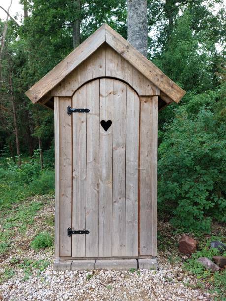 A neat wooden toilet in the forest. House with a heart