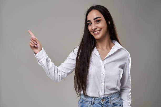 istock Young woman in jeans against gray background 2162919836