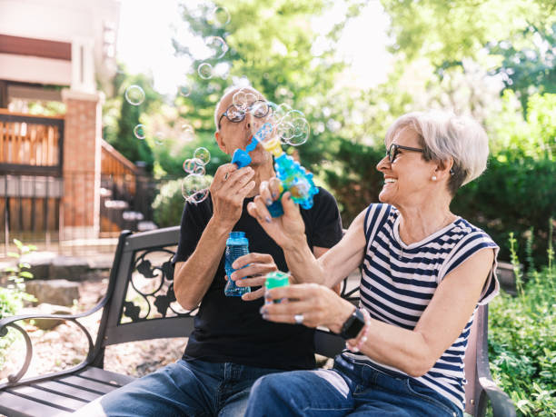 istock Senior couple making soap bubbles in the home garden 2162924910