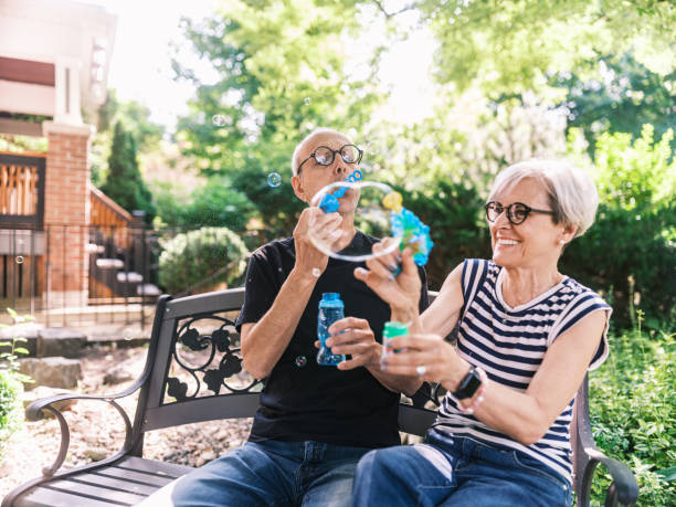istock Senior couple making soap bubbles in the home garden 2162924913