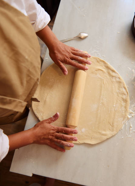istock Person rolling out dough with a rolling pin on a marble surface in a kitchen 2162933397
