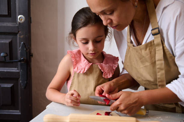 istock Mother and daughter cooking together in kitchen, teaching and bonding 2162933825