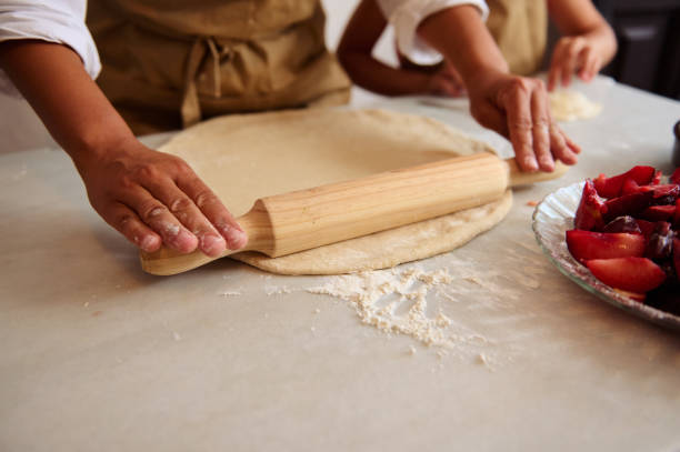 istock Hands rolling out dough with a wooden rolling pin for a homemade pie 2162935506