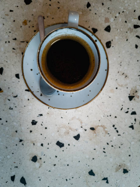 istock Small decorative cup of black coffee standing on table with terrazzo pattern in small cafe 2162937151