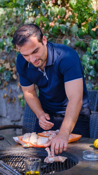 Two adults share a simple outdoor meal during a family camping session, cooking over a small camp fire in a sunlit forest. The scene evokes bonding, fresh air, and a digital detox, Family Camping Digital Detox.