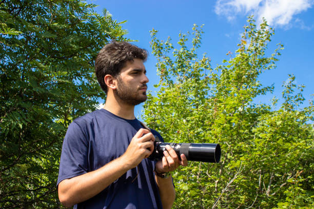 Young man taking photos in nature