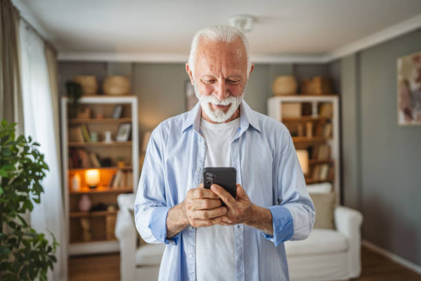 istock Portrait of senior man stand and use mobile phone at home 2162943607
