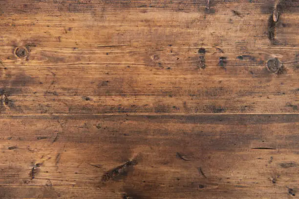 Wood texture background. Top view of vintage wooden table with cracks. Surface of old knotted wood with natural color, texture and pattern. Wood texture background. Top view of vintage wooden table with cracks. Surface of old knotted wood with natural color, texture and pattern.