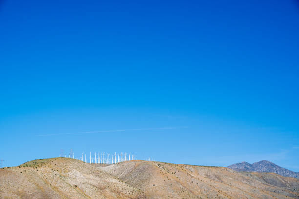 Row of Cabazon windmills on top of the San Gorgonio Pass hills with blue sky and copy space