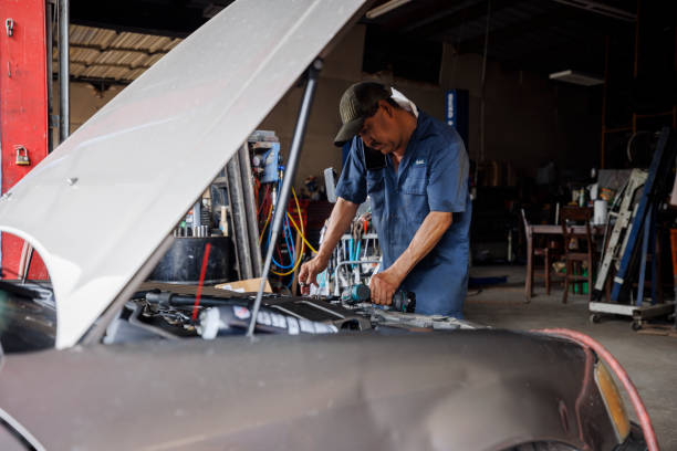 istock Skilled technician diagnosing vehicle issues. Middle-aged Latino mechanic utilizes diagnostic tool on car engine. 2162955599