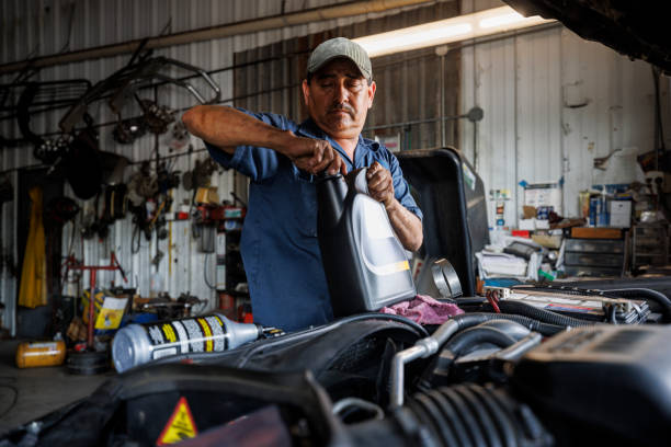 istock Skillful automotive technician services engine. 57-year-old Latino repairman performs routine maintenance. 2162955625